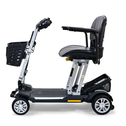 The Golden Technologies Portable Buzzaround GB120 Carry-On Travel Scooter is a compact, foldable mobility scooter equipped with a black seat, four wheels, and a front basket. It includes an ultra-portable lithium-ion battery and is pictured in profile view against a white background.