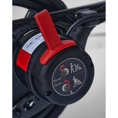 Close-up of the Golden Cricket™ LT Carbon Powerchair’s control switch with red lever—choose Manual or Electric mode for unmatched freedom. Inspired by its 25 lb lightweight carbon design, this switch offers precise, reliable performance.