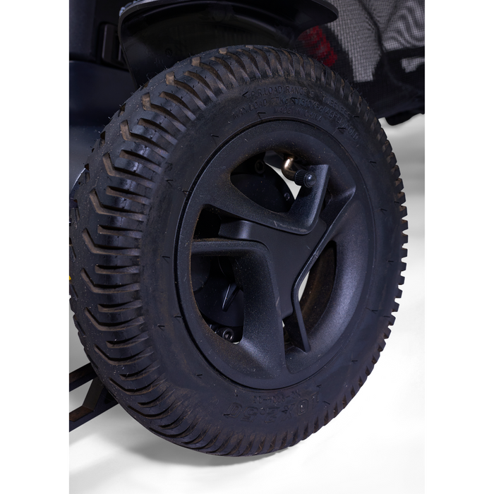 Close-up of a black, rugged tire with deep treads and a star-shaped spoke pattern on a white background, showcasing the advanced robotics precision in the Golden Tech Ally Pro Smart All-Terrain Power Wheelchair with APP Controls omni-directional wheels.