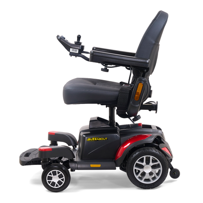 A side view of a black and red Golden Tech BuzzAbout Portable Power Wheelchair featuring a cushioned seat, armrests, joystick control, and four wheels. The word "BuzzAbout" appears on the side.