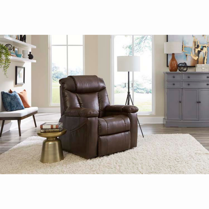 A brown Golden Tech Rhea PR442 MaxiComfort Recliner with Lift Assist & HeatWave sits on a fluffy white rug in the living room. Nearby is a small round gold side table, and the 4-Zone Comfort Zone enhances relaxation, while large windows, a gray sideboard, modern floor lamp, pillows, and artwork add charm.