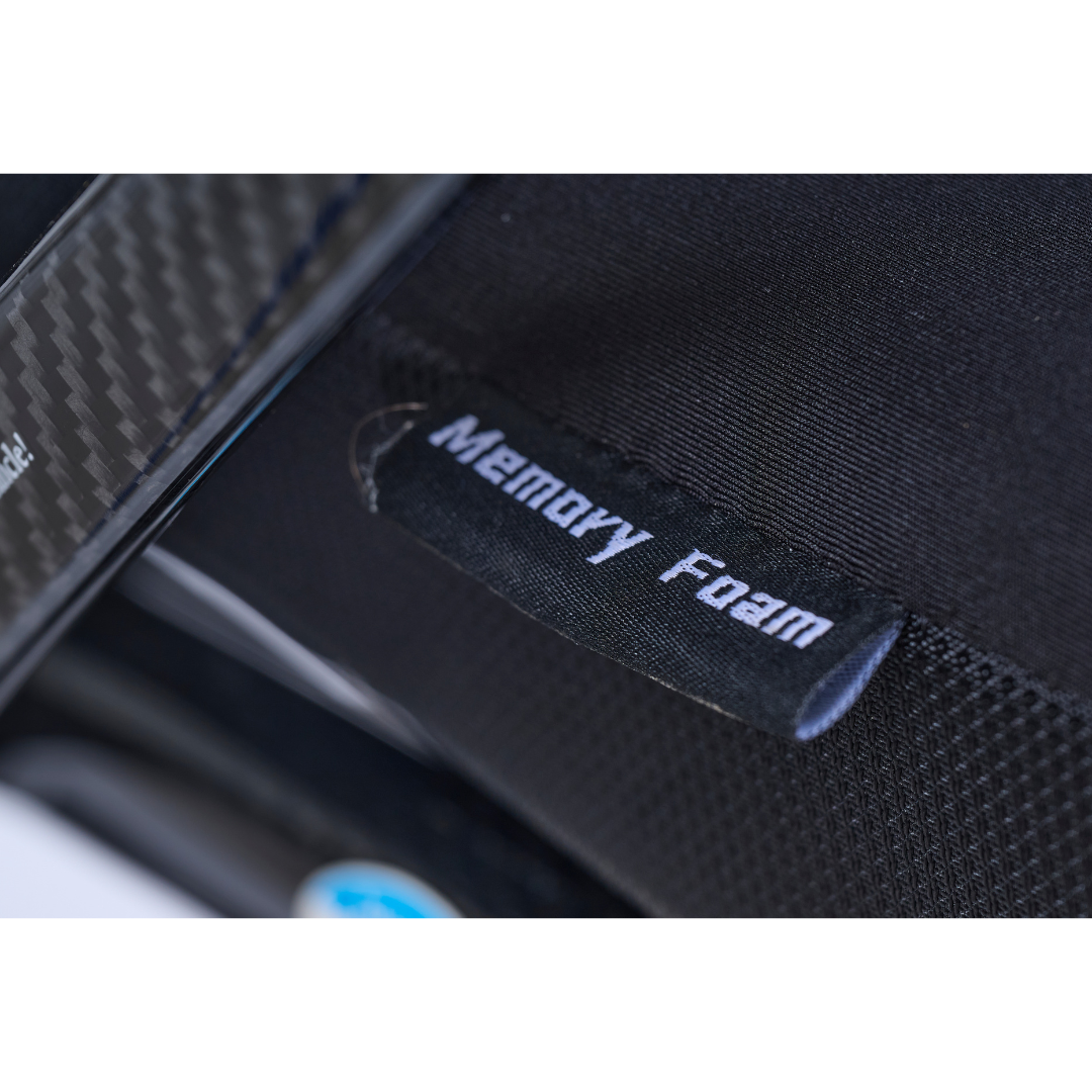 Close-up of a black fabric tag labeled Memory Foam attached to a textured black surface, likely part of the Golden Cricket™ LT Carbon Portable Lightweight Powerchair, which weighs only 25 lbs.
