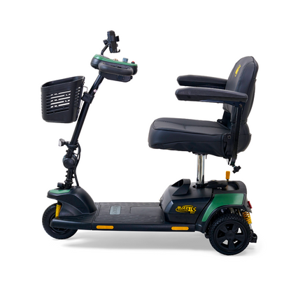 Side view of a green and black Golden Tech GB121 Buzzaround XLS HD scooter with a delta tiller, padded seat, armrests, handlebar controls, and front basket. Featuring three wheels and Comfort Spring Suspension for enhanced comfort.