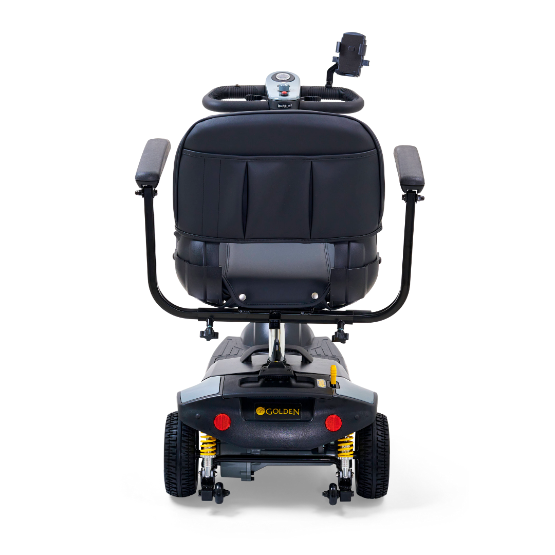 Rear view of the Golden Tech GB121 Buzzaround XLS HD scooter, featuring a black cushioned seat, armrests, control panel, small backrest, and Golden branding on the rear. This 3-wheel portable scooter includes Comfort Spring Suspension for smoother rides.