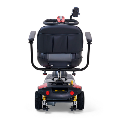 A rear view of the Golden Tech GB121 Buzzaround XLS HD 3-wheel portable scooter showcases a sleek black design with gold accents, Delta tiller, and storage pocket on the seat back. The handlebars and rear wheels enhance its appearance, with Golden proudly printed on the base.