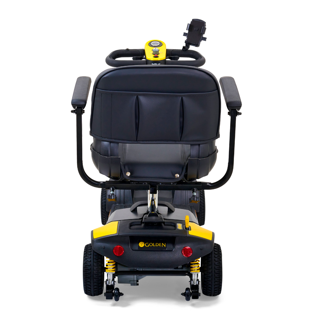 Rear view of the Golden Tech GB124 Buzzaround XLS HD, a black mobility scooter with cushioned seat and armrests. It features a brand logo at its base, red lights, and black wheels with yellow accents. Includes back control panel and Comfort Spring Suspension for added stability.