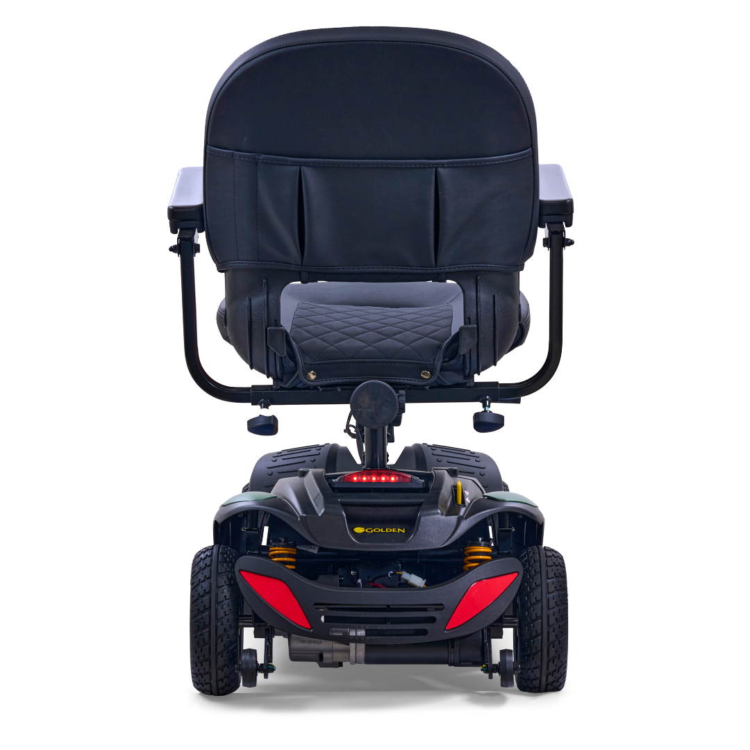 The rear view of the Golden Tech GB148 Buzzaround EX Portable Mobility Scooter shows a padded black seat with armrests, storage underneath, a lightweight four-wheel base, streamlined design, and two striking red accents at the back.