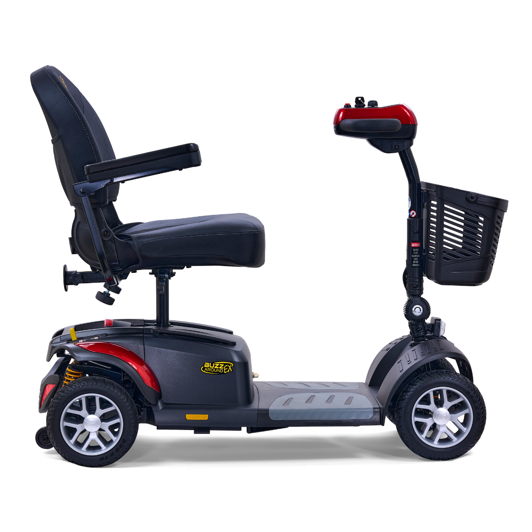 The Golden Tech GB148 Buzzaround EX Portable Mobility Scooter is a sleek mobility scooter, featuring four wheels, a padded seat, armrests, and a front basket. It has a compact design with striking red accents on the tiller against a clean white and black color scheme.