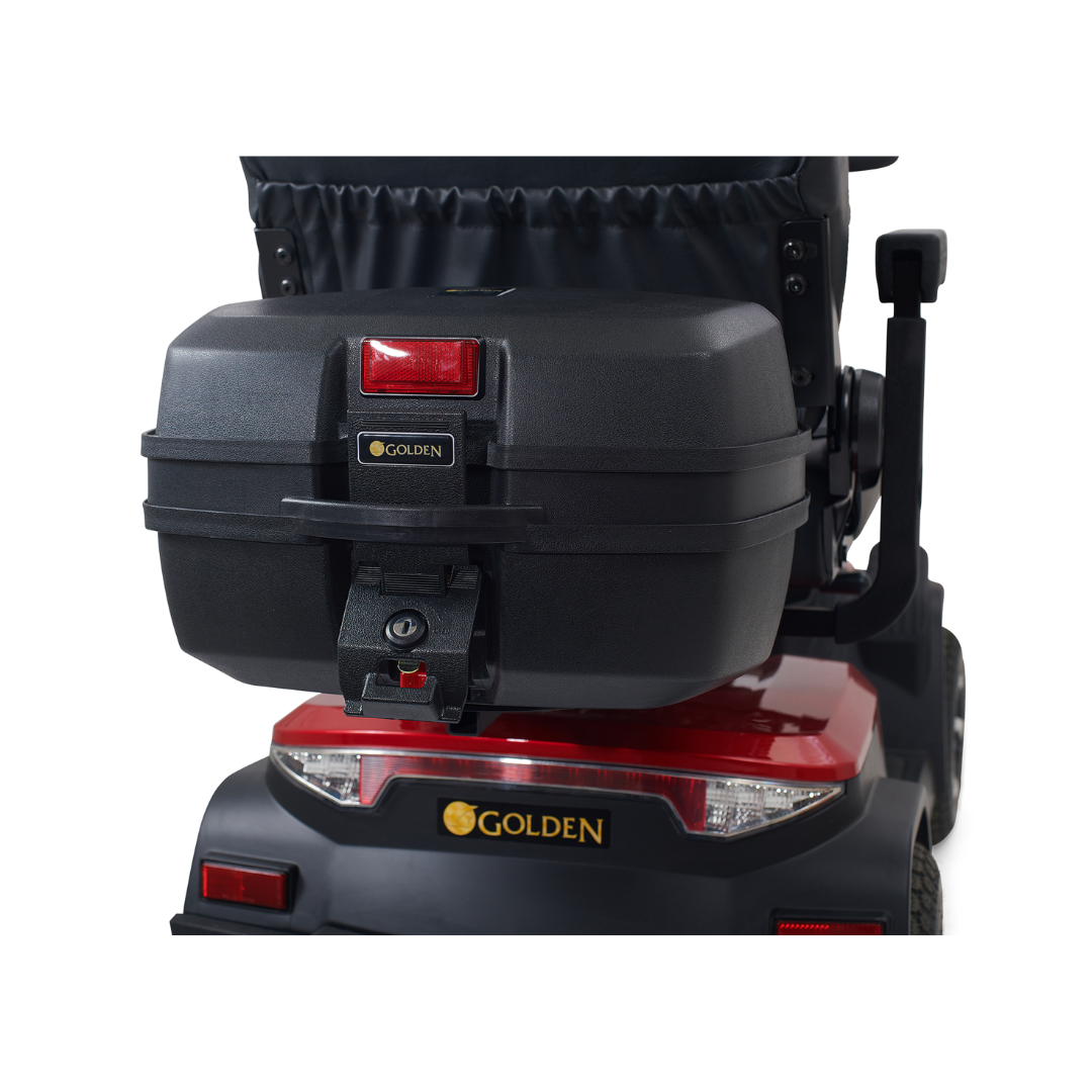 Close-up of the rear of a Golden Tech Eagle HD Bariatric 4-Wheel Scooter, showcasing a storage box with a red reflector and iconic golden logo. The scooter, designed for style and off-road performance, boasts taillights and a sleek red-and-black color scheme.