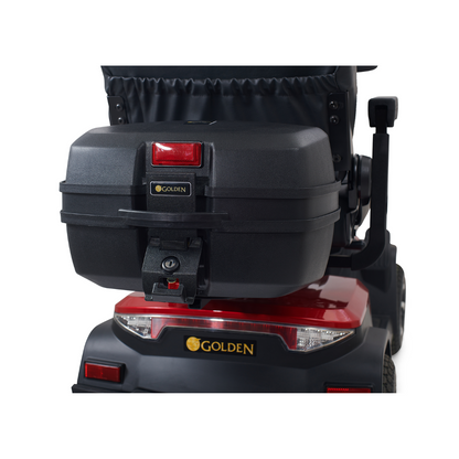 Close-up of the rear of a Golden Tech Eagle HD Bariatric 4-Wheel Scooter, showcasing a storage box with a red reflector and iconic golden logo. The scooter, designed for style and off-road performance, boasts taillights and a sleek red-and-black color scheme.