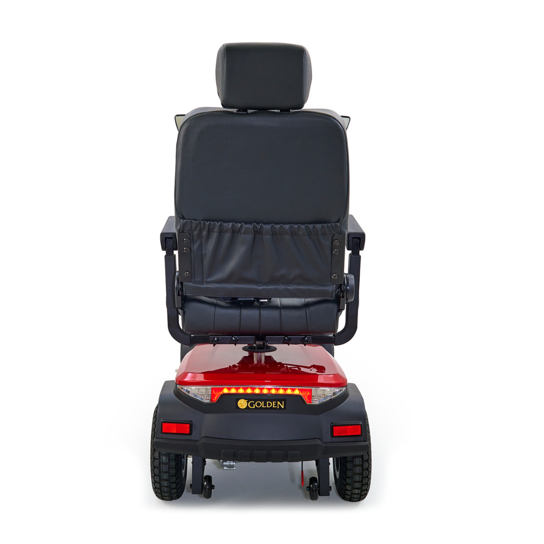 Rear view of a red Golden Tech Eagle HD Bariatric 4-Wheel Scooter with Suspension highlighting off-road performance. The cushioned black seat and headrest offer comfort, while large rear wheels provide stability for outdoor adventures. Brand name Golden is prominently shown on the back panel.