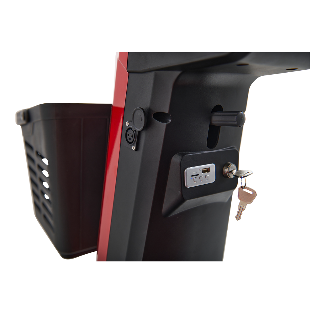 Close-up of the charging port area on the Golden Tech Eagle HD Bariatric 4-Wheel Scooter with Suspension, showcasing a key and lock mechanism, USB port, and plug socket. Ideal for outdoor adventures, it features a convenient storage basket on one side.