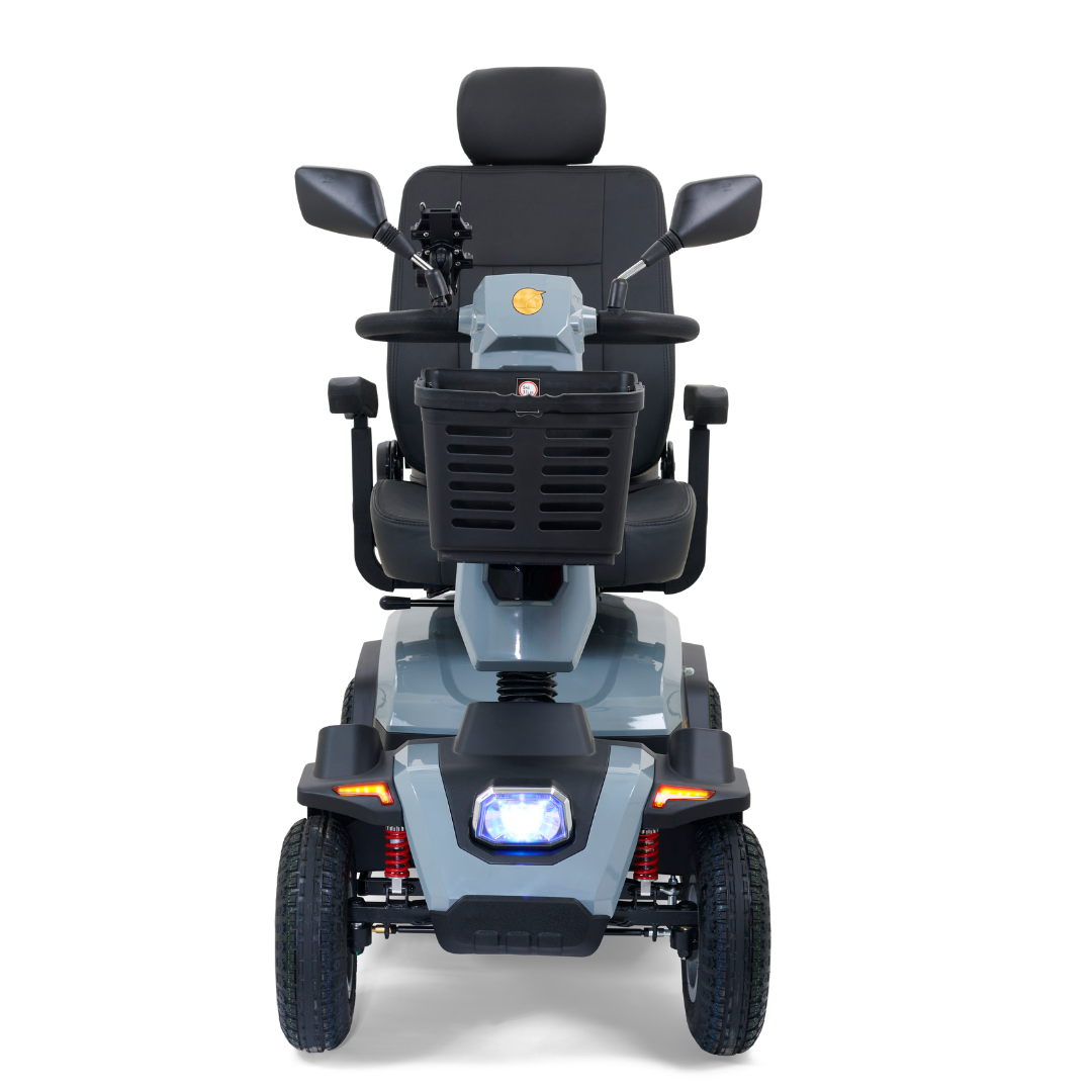 Front view of the Golden Tech Eagle HD Bariatric 4-Wheel Scooter with Suspension, designed for comfort and off-road use. It features a padded seat, armrests, four wheels, a handlebar basket, rearview mirrors, and a headlight on its gray and black frame for outdoor adventures.