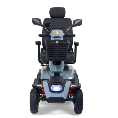 Front view of the Golden Tech Eagle HD Bariatric 4-Wheel Scooter with Suspension, designed for comfort and off-road use. It features a padded seat, armrests, four wheels, a handlebar basket, rearview mirrors, and a headlight on its gray and black frame for outdoor adventures.