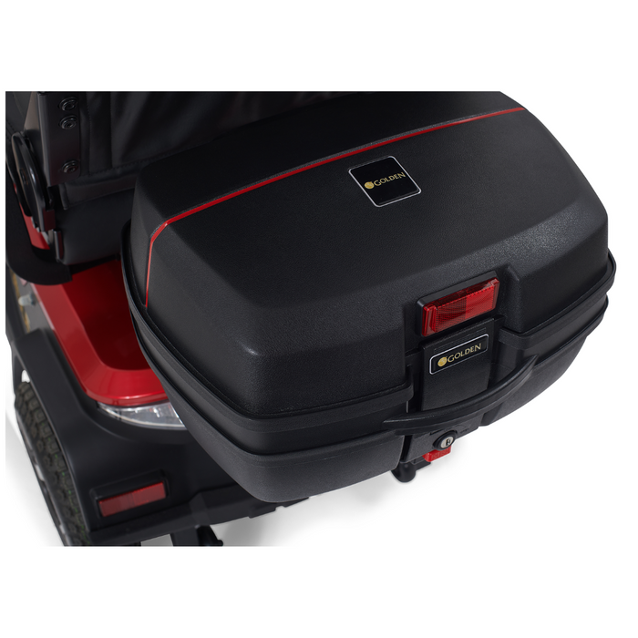A close-up of a black storage compartment with a red stripe on the rear of a Golden Tech Eagle HD Bariatric 4-Wheel Scooter, known for off-road performance. The compartment shows a Golden logo, a visible red reflector, and partially visible rear lights.