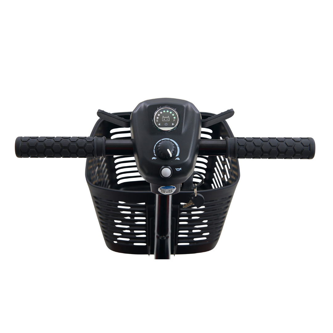 Close-up of the Golden Tech GB108 Buzzaround LT 4-Wheel Mobility Scooter handlebar with textured grips, a circular speedometer, and key ignition. A black wire basket is attached below, offering style and practicality for every journey.