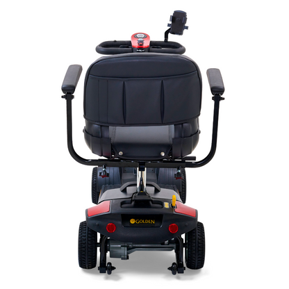 The Golden Tech GB124 Buzzaround XL 4-Wheel Portable Mobility Scooter is black and red, showcasing a padded seat, dual armrests, and a control panel on the handlebar. It offers enhanced maneuverability with four wheels and includes a small storage compartment. Golden is printed in yellow at the back.