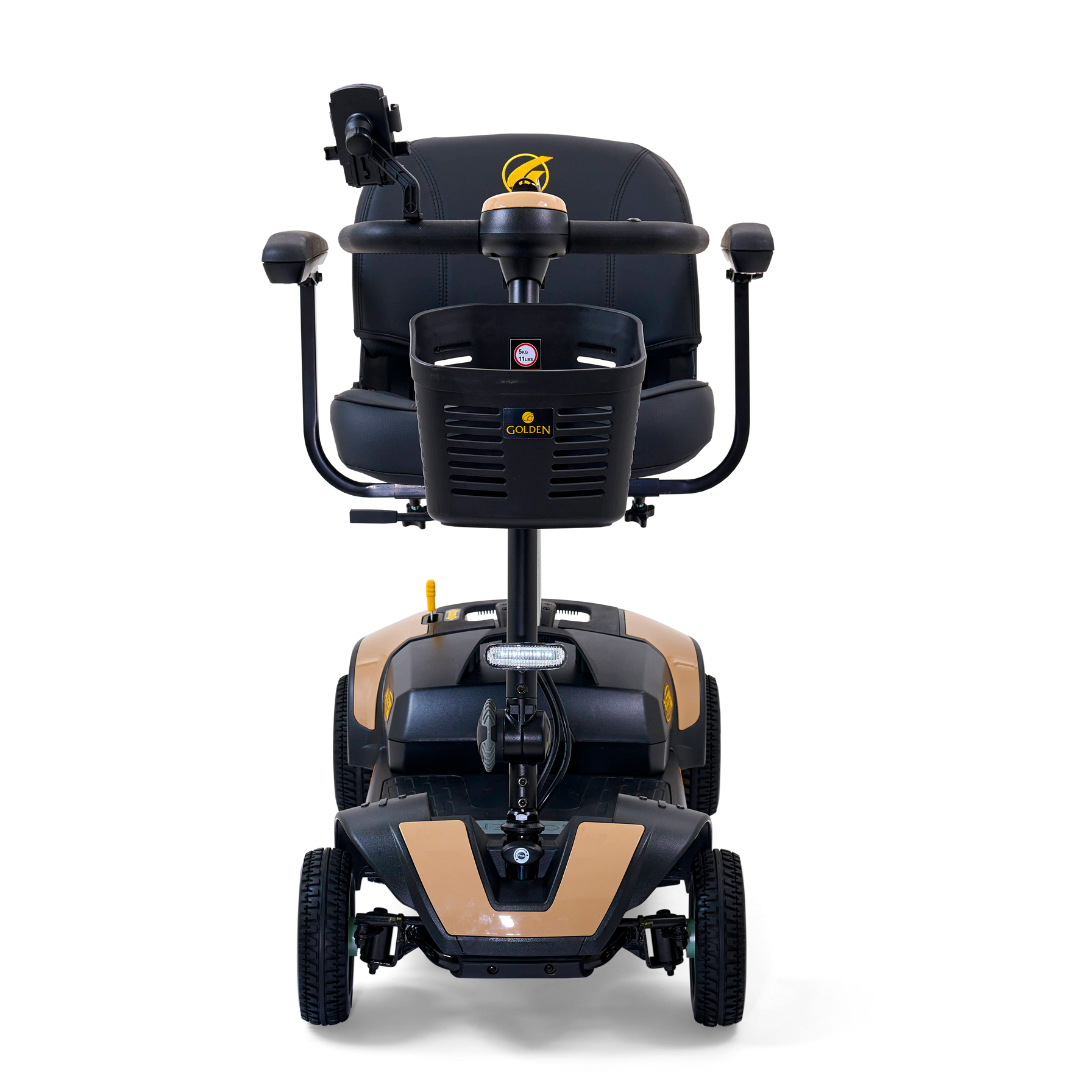 Front view of the Golden Tech GB124 Buzzaround XL 4-Wheel Portable Mobility Scooter in black and beige. It boasts enhanced maneuverability, a cushioned seat with armrests, and a tiller with handlebars.