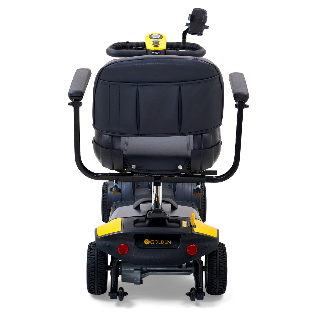 Rear view of a Golden Tech GB124 Buzzaround XL 4-Wheel Portable Mobility Scooter in yellow and black, featuring armrests, large rear wheels, a handlebar on top, and the brand name Golden visible on the back. Designed for exceptional maneuverability.