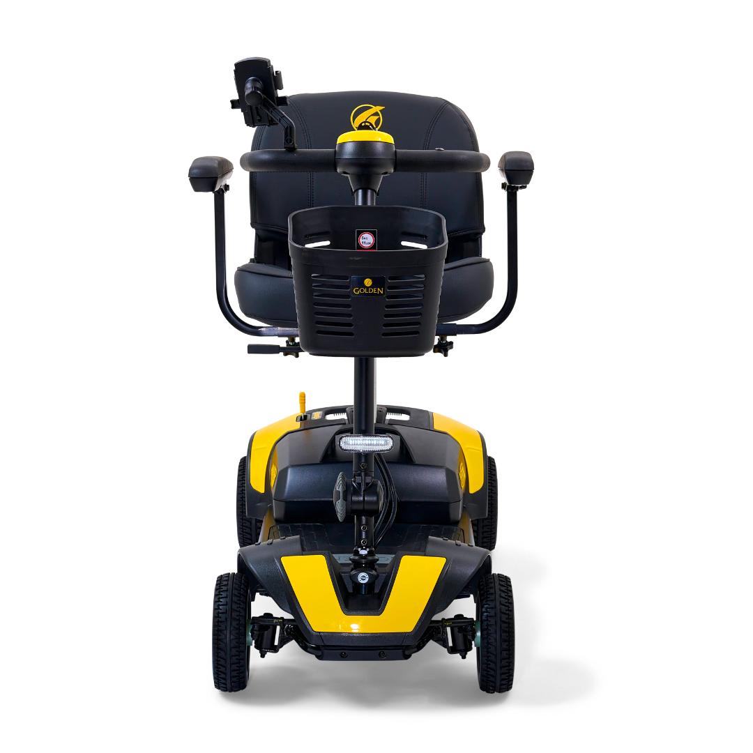 The Golden Tech GB124 Buzzaround XL 4-Wheel Portable Mobility Scooter, shown in yellow and black from the front view, features four wheels, handlebars, and a padded seat with armrests. It includes an extended range battery and a small front basket, ideal for those on the go.
