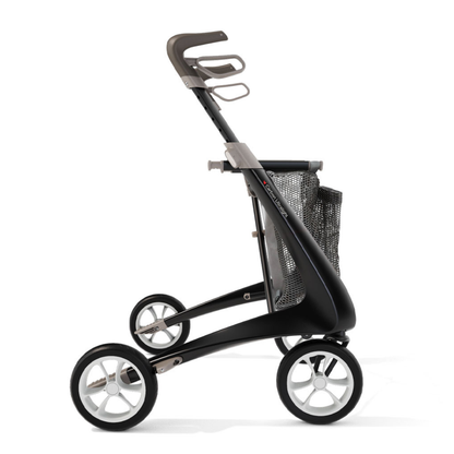 A modern black and gray rollator walker with four large wheels, ergonomic handles, a mesh storage basket, and the Grocery Bag For ByAcre Carbon Fiber Rollators for convenient shopping.