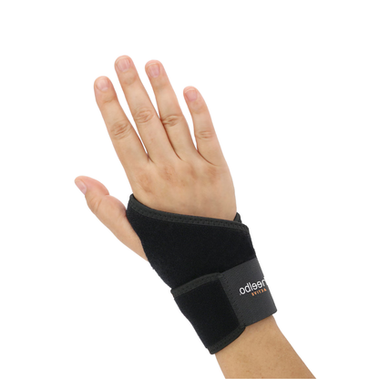A left hand wearing a Heelbo® Universal Support Wrist Compression Brace with a visible Velcro strap, shown against a white background.