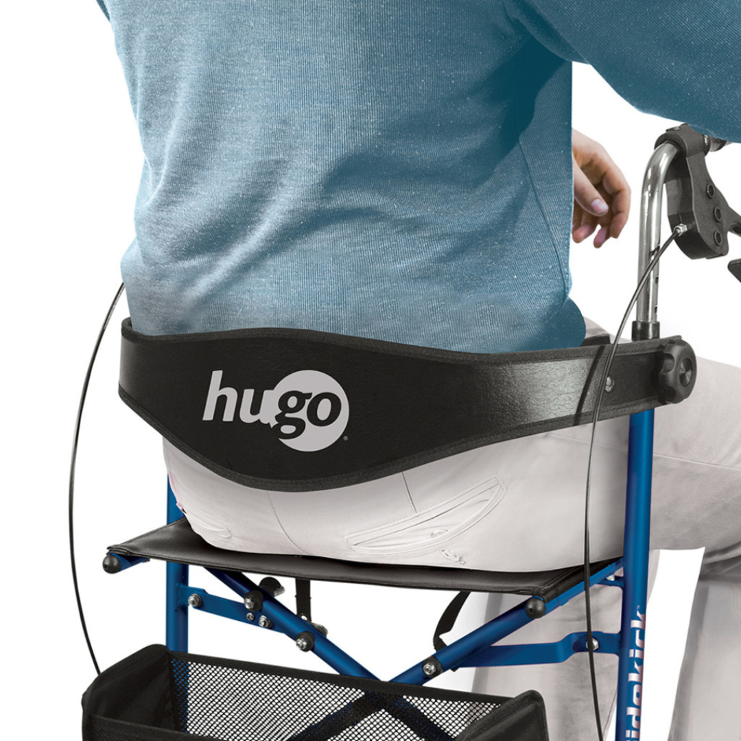 A person in a blue sweater and white pants sits on a Drive Hugo Sidekick Side-Folding Rollator, featuring a black mesh back support and an under-seat storage basket.