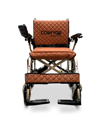 The ComfyGo X-7 Lightweight Foldable Electric Wheelchair weighs only 40 lbs and features a brown quilted backrest with ComfyGO mobility, a cross-brace design for stability, a right-armrest joystick, black footrests, and a metallic frame—ideal for portable mobility needs.