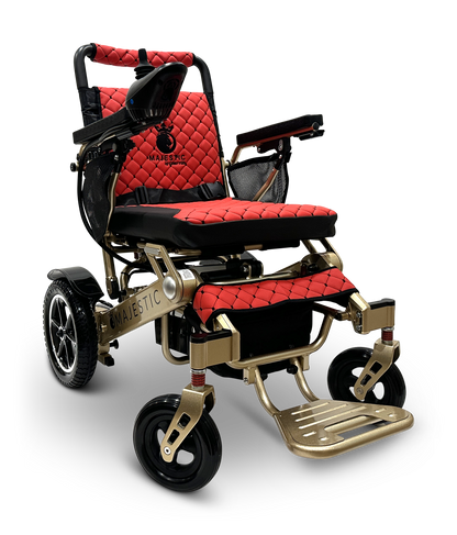 The MAJESTIC IQ-7000 Auto Folding Remote Controlled Electric Wheelchair features a red and black quilted design, sturdy frame with armrests containing a 360-degree joystick for easy navigation, and four wheels for smooth mobility. The Majestic branding is visible on the side and backrest.