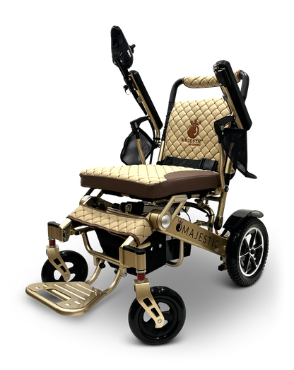The MAJESTIC IQ-7000 Remote Controlled Electric Wheelchair, adorned in a luxurious gold and black design with quilted upholstery, the Majestic logo, footrest, and adjustable armrests, is elegantly presented against a black background.