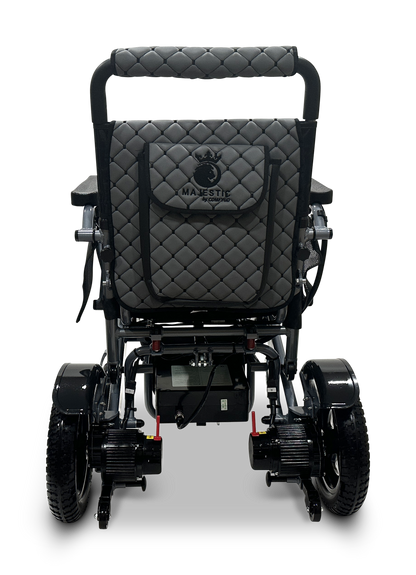 The image shows the back of a MAJESTIC IQ-7000 Remote Controlled Electric Wheelchair with a quilted gray and black design, four wheels, battery compartments, armrests, and a 360-degree joystick for easy navigation.