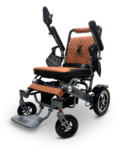The MAJESTIC IQ-7000 is a sleek folding electric wheelchair with a quilted brown leather seat and backrest, robust black metal frame, armrests, large rear wheels, smaller front wheels, folding footrest, advanced 360-degree joystick control, and the brand name Majestic visible on the side.