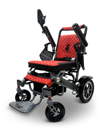 The MAJESTIC IQ-7000 is a red and black folding electric wheelchair with a quilted seat, adjustable armrests, large rear wheels, small front wheels, and a 360-degree joystick for easy maneuvering, ensuring stylish convenience on the go.