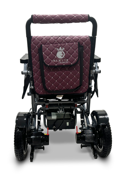 The MAJESTIC IQ-7000 Auto Folding Remote Controlled Electric Wheelchair features a quilted maroon backrest with branding and a horse logo, four black wheels, a visible battery compartment, foldable handles, and a 360-degree joystick for easy navigation.