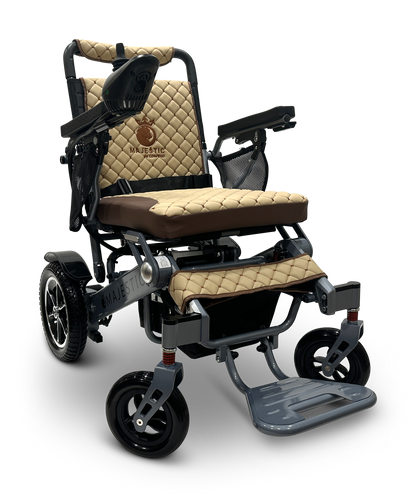 The MAJESTIC IQ-7000 is a beige and brown folding electric wheelchair with a quilted seat and backrest. It features black armrests, a 360-degree joystick for easy maneuvering, visible footrests, and larger rear wheels for added stability.