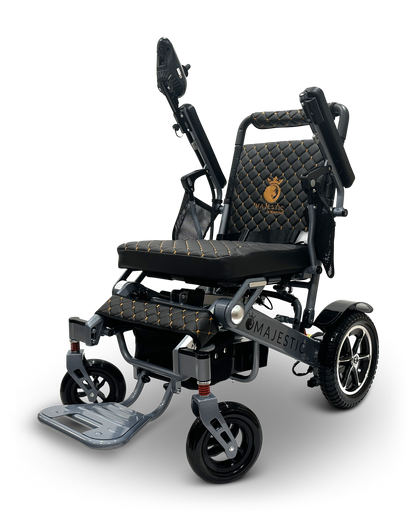 The MAJESTIC IQ-7000 is an auto-folding, black and gold electric wheelchair with a quilted seat, backrest logo, armrests, footplate, and spring suspension wheels. Its lightweight design includes a 360-degree joystick for effortless maneuverability.