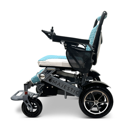 Side view of the MAJESTIC IQ-7000 Auto Folding Remote Controlled Electric Wheelchair with a black frame, teal and gray cushioned seat, 360-degree joystick control on the armrest, side storage pouch, and sturdy black wheels with silver spokes.