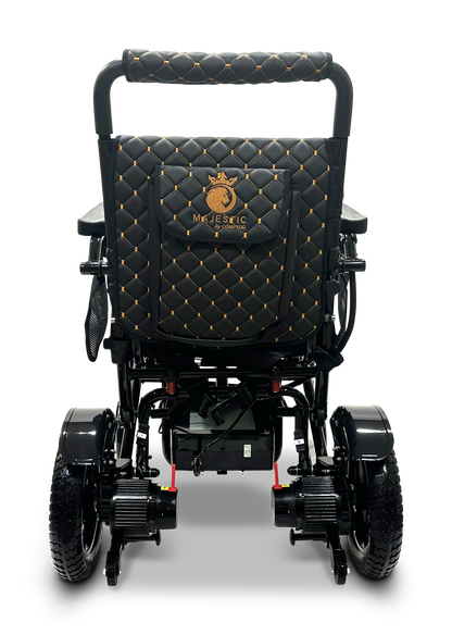 Introducing the MAJESTIC IQ-7000 Remote Controlled Electric Wheelchair in black, featuring a quilted backrest adorned with elegant gold stitching and a prominent Majestic logo. This sleek, lightweight wheelchair offers robust wheels for seamless mobility, perfectly merging sophistication with functionality.