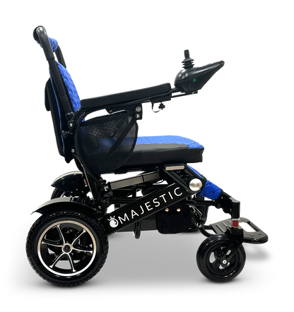 A Majestic IQ-7000, a blue and black auto-folding electric wheelchair equipped with an intelligent joystick controller and footrest, is displayed with the brand name prominently on its side against a plain background.