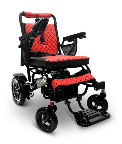 The MAJESTIC IQ-7000 Remote Controlled Electric Wheelchair showcases a quilted red and black seat design, with folding armrests and footrest. It includes a right-side joystick control and features a robust black frame proudly displaying the Majestic branding, offering the perfect blend of style and practicality.