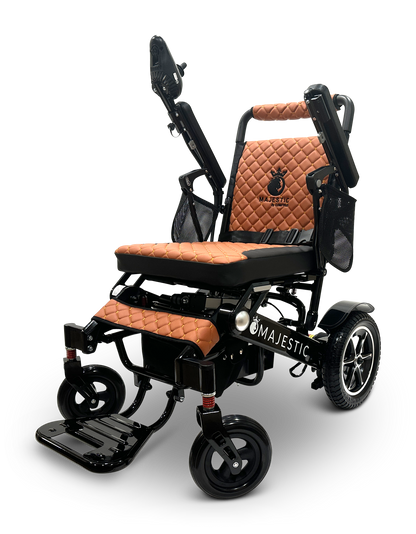 The MAJESTIC IQ-7000 Auto Folding Remote Controlled Electric Wheelchair is available in black and brown, featuring a quilted seat and backrest. It comes with an intelligent joystick control on the right arm, a folding footrest, and supportive armrests. The Majestic brand name is prominently displayed on its auto-folding frame.
