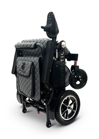 MAJESTIC IQ-7000 Remote Controlled Electric Wheelchair, featuring a quilted design with folded black and gray elements, small rear wheels, and a control panel, set against a plain black background.