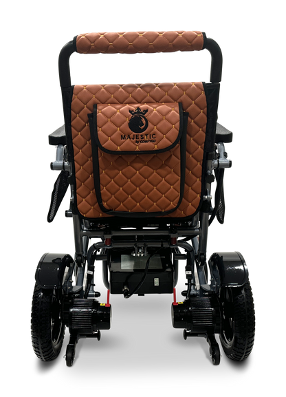 The MAJESTIC IQ-7000 Auto Folding Remote Controlled Electric Wheelchair features a luxurious quilted brown leather backrest with a pocket and logo. Its black frame, sturdy wheels for all terrains, and 360-degree joystick offer comfort and precision control.