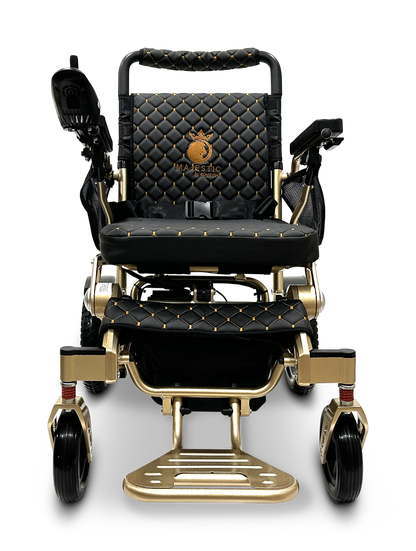 The MAJESTIC IQ-7000 Remote Controlled Electric Wheelchair comes in an elegant black and gold design with a quilted pattern and a lion emblem on the backrest. It is a lightweight motorized transport chair that includes armrests, footrests, and a joystick control conveniently located on the right armrest.