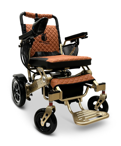 The MAJESTIC IQ-7000 Electric Wheelchair features lightweight, auto-folding design with gold and orange quilted upholstery, a sturdy metal frame, black-armrest cushioned seat, and small front wheels for agility. A 360-degree joystick on the right arm provides seamless control.