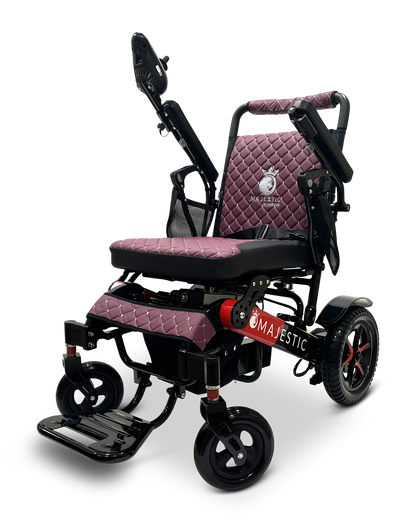 The MAJESTIC IQ-7000 Auto Folding Remote Controlled Electric Wheelchair boasts an intelligent joystick and a stylish maroon quilted seat with adjustable armrests. Its elegant black frame is designed with small front and rear wheels, featuring the name Majestic prominently on the side.