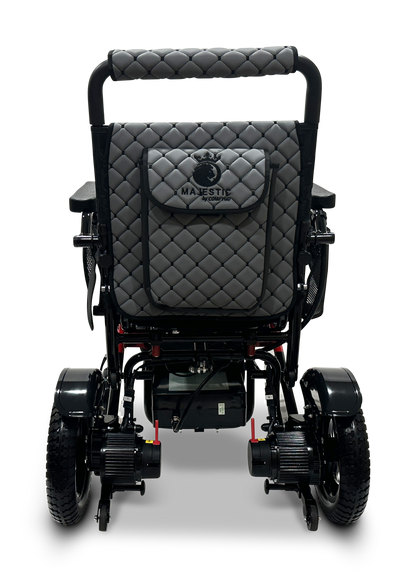 The rear view of the lightweight black MAJESTIC IQ-7000 Remote Controlled Electric Wheelchair showcases a quilted backrest with the word MAJESTIC and a crown logo. This auto-folding model is designed with two large wheels and two smaller ones to enhance stability.