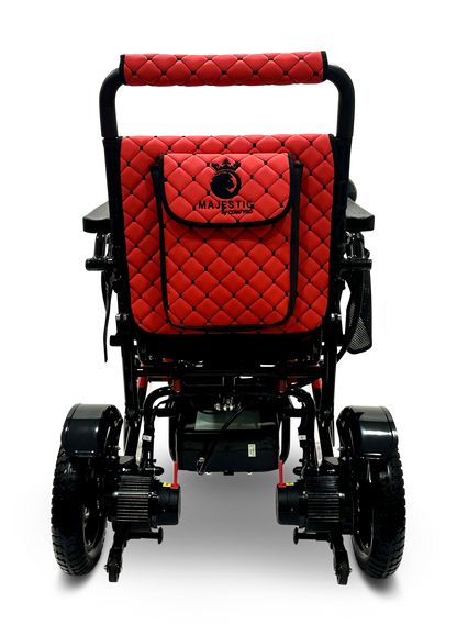The MAJESTIC IQ-7000 Remote Controlled Electric Wheelchair is a lightweight device in red and black, featuring quilted upholstery and the word "MAJESTIC" on the backrest. It comes equipped with an intelligent joystick for effortless control, large rear wheels paired with smaller front ones, all presented in a sleek, modern design.