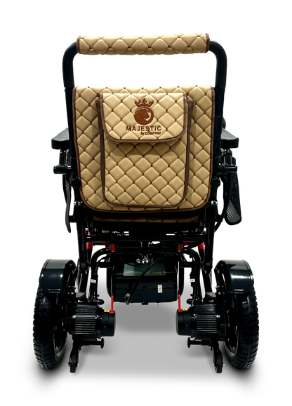 The MAJESTIC IQ-7000 Remote Controlled Electric Wheelchair features a sleek black design with a cushioned, quilted tan backrest and a matching storage pouch. This lightweight model includes rugged black wheels, an auto-folding feature, and a visible battery compartment underneath.