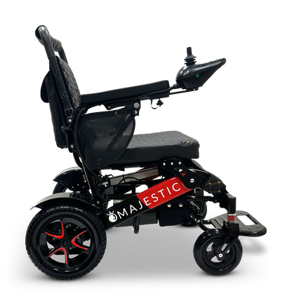 The MAJESTIC IQ-7000 Remote Controlled Electric Wheelchair is a black auto-folding model with red accents, equipped with a padded seat and armrests. It features an intelligent joystick on the right armrest and has an upright backrest, along with sturdy wheels for enhanced mobility. "MAJESTIC" is inscribed on the lower frame.